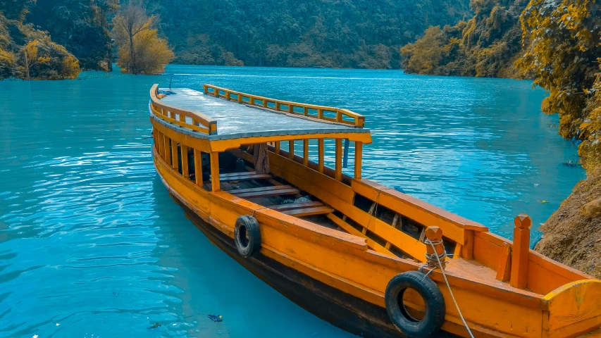 a yellow boat sitting in water near land