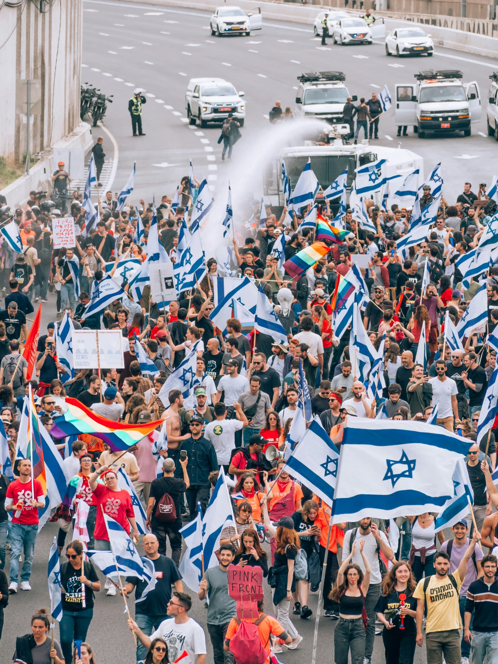 group of people holding flags while walking down street