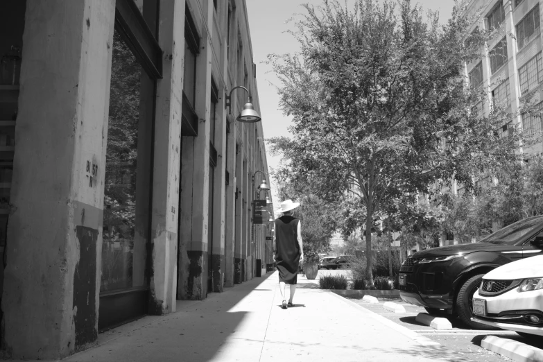 a man stands on the sidewalk by his car