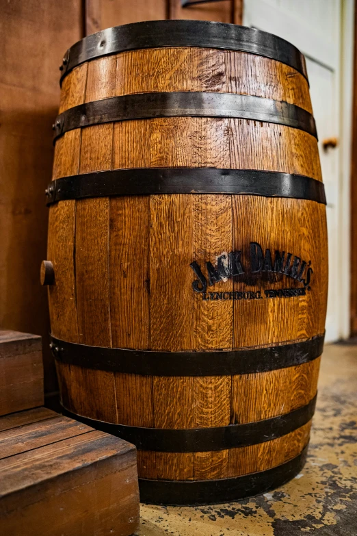 a wooden barrel sitting on top of a floor next to another wooden box