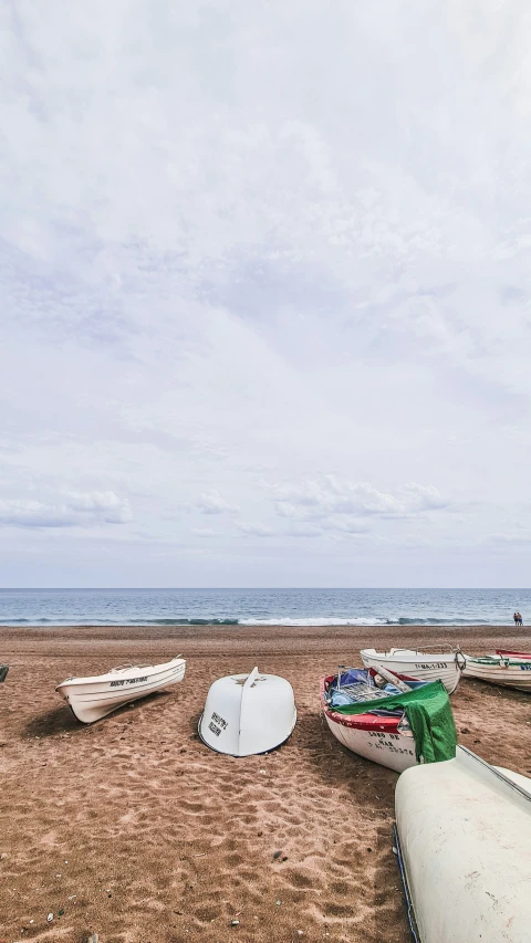 several boats sitting in the sand at the beach