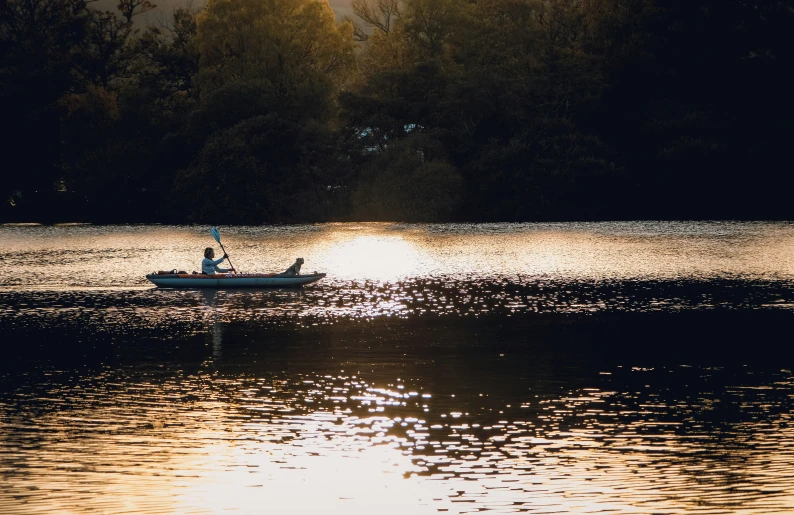 two people rowing a canoe on a lake