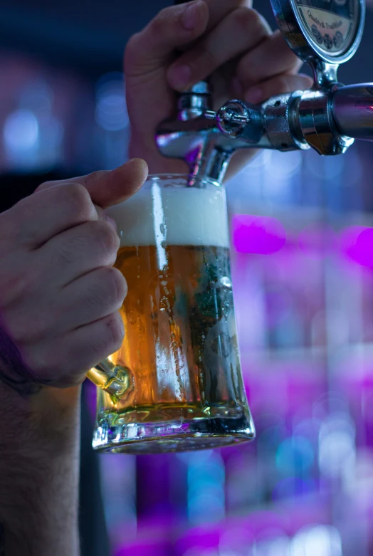 a man holding a beer while he pours soing