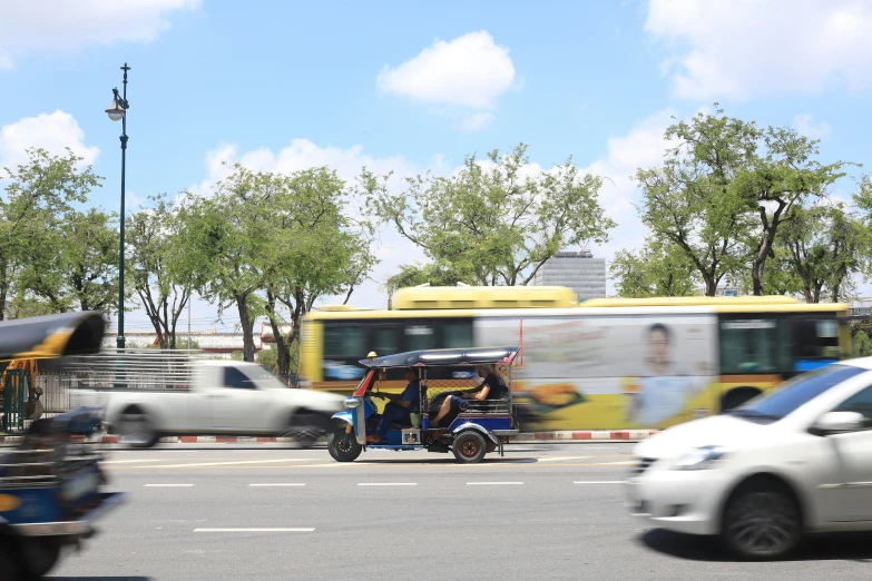 two motorcycles and three buses are driving down the road