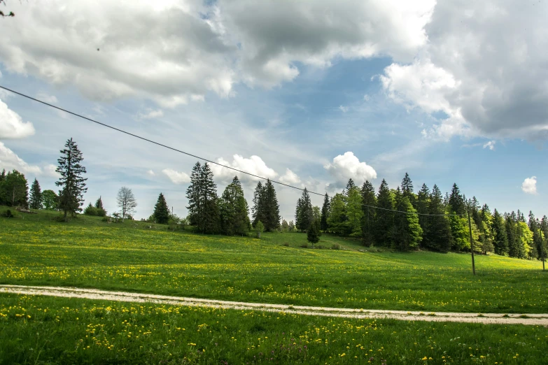 the sky is filled with clouds, trees, and fields