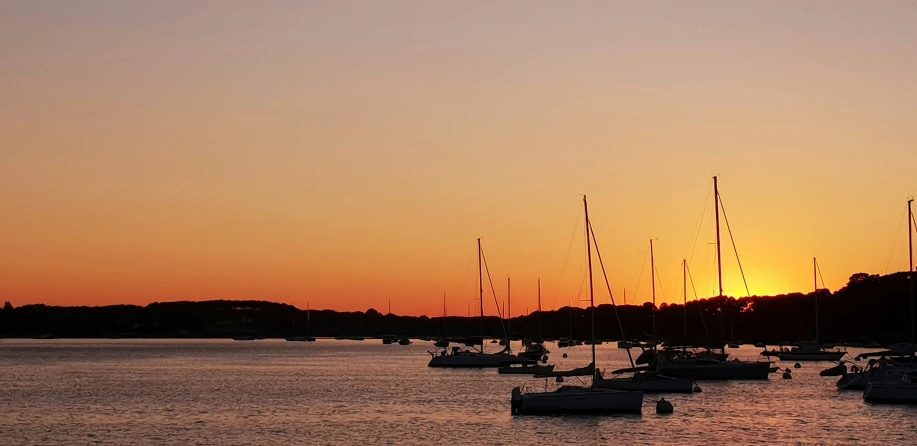 a sunset reflecting off the water and boats