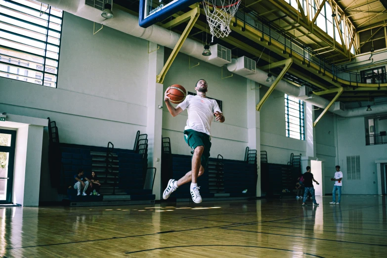 a man in white and green playing a game of basketball