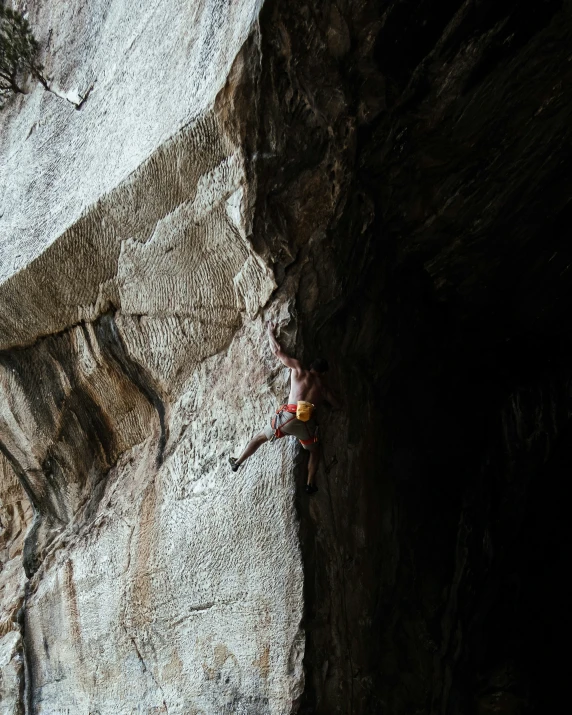 a man climbing up a cliff in the dark