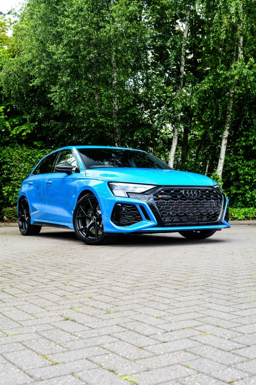 an all - electric blue audi rs q3 is parked in a driveway