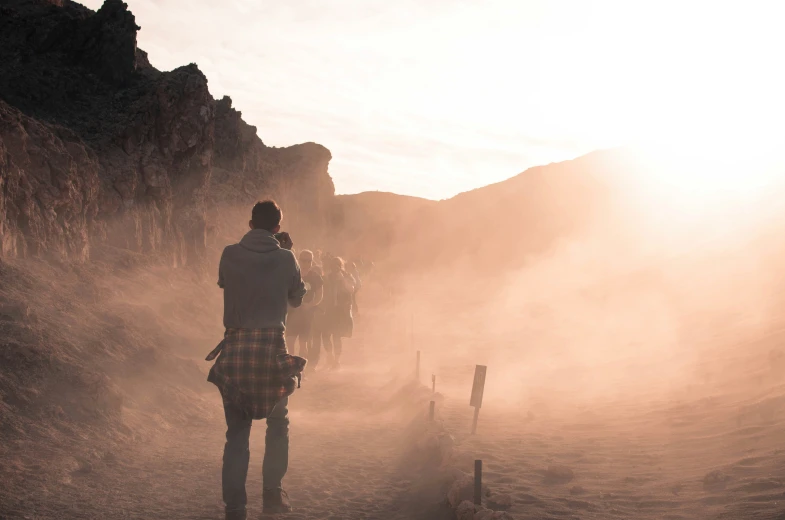 a group of people in dress standing at the edge of a cliff