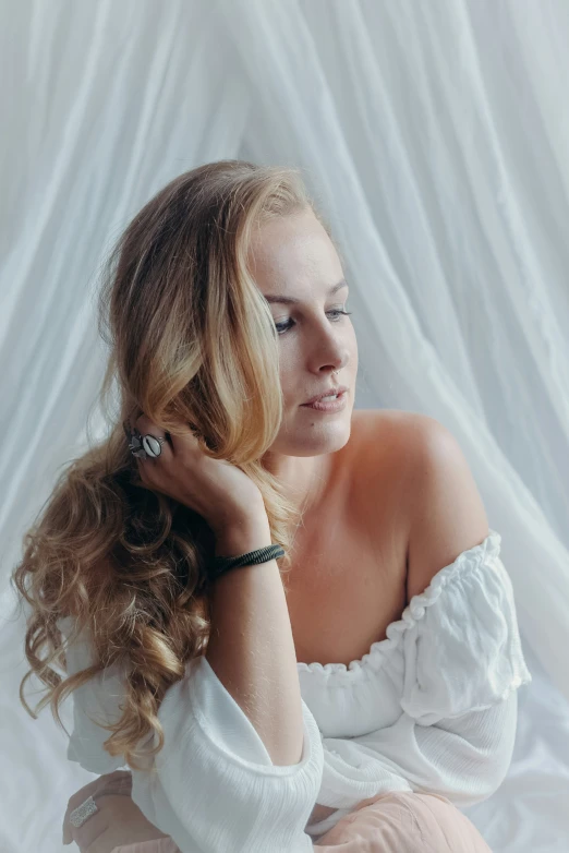 a young woman with long curly hair, sitting down