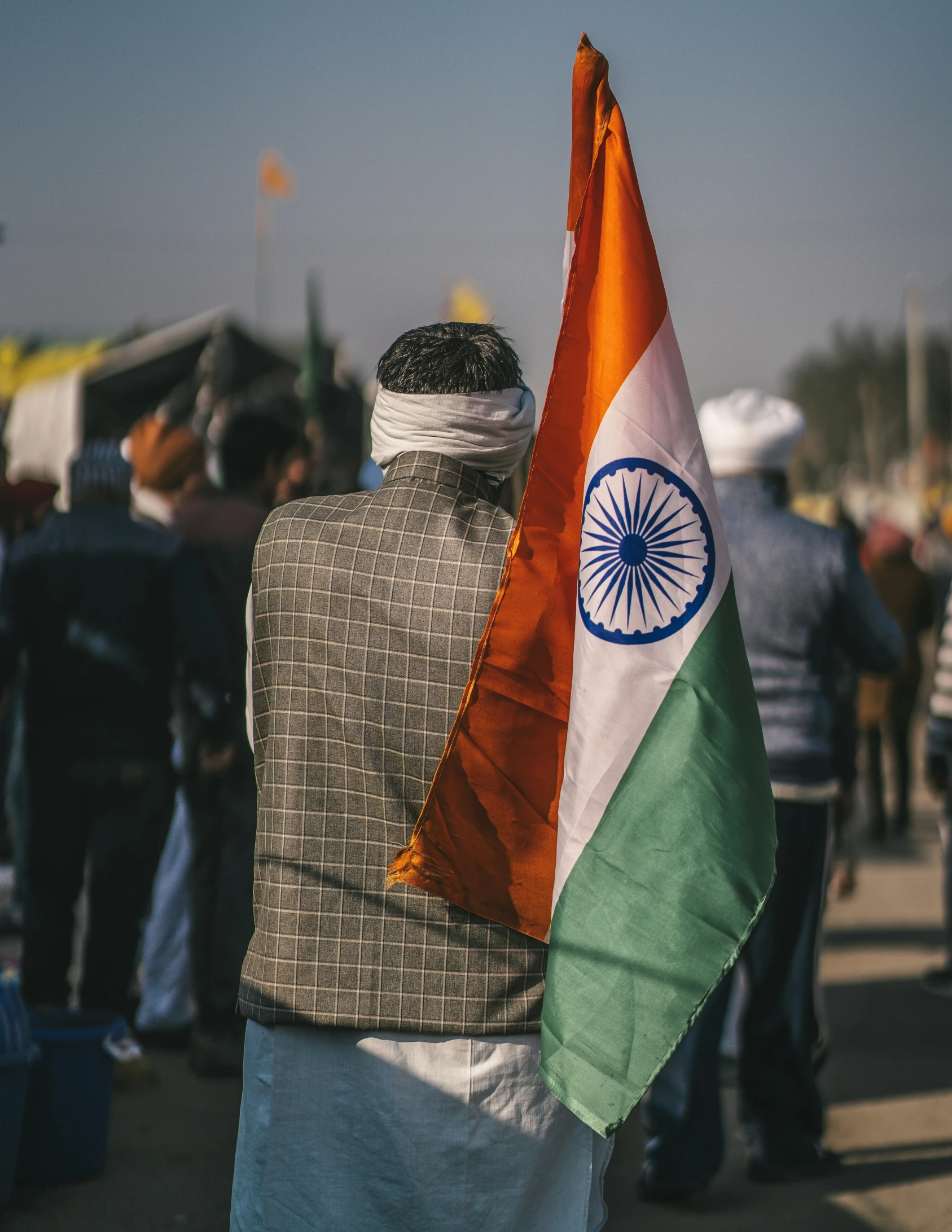 a man is walking with the flag of india