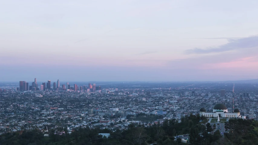 a view of an city and the sky from a hill