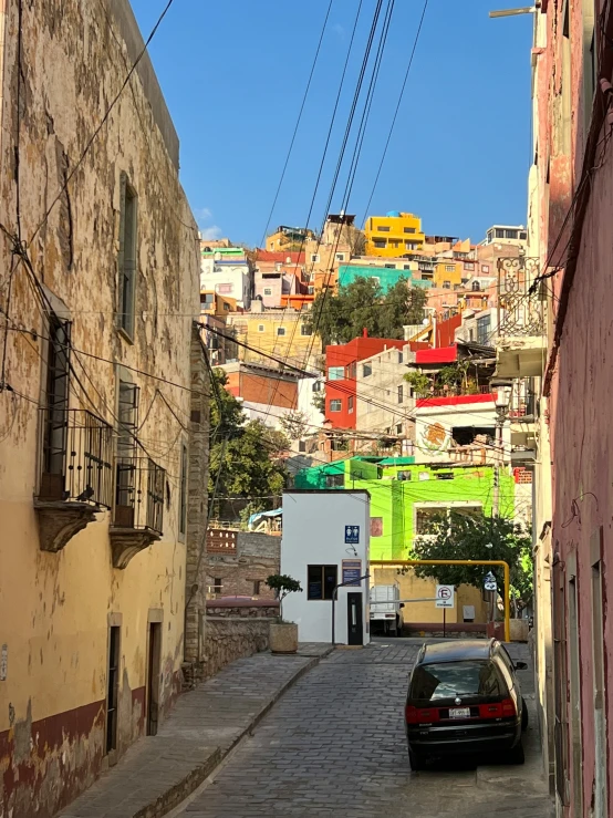 a car parked on the side of a street next to a building