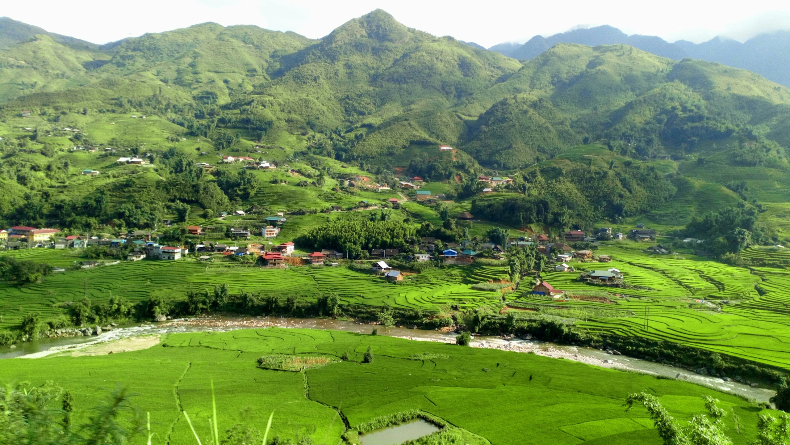 a hill and land area with a small village on the side