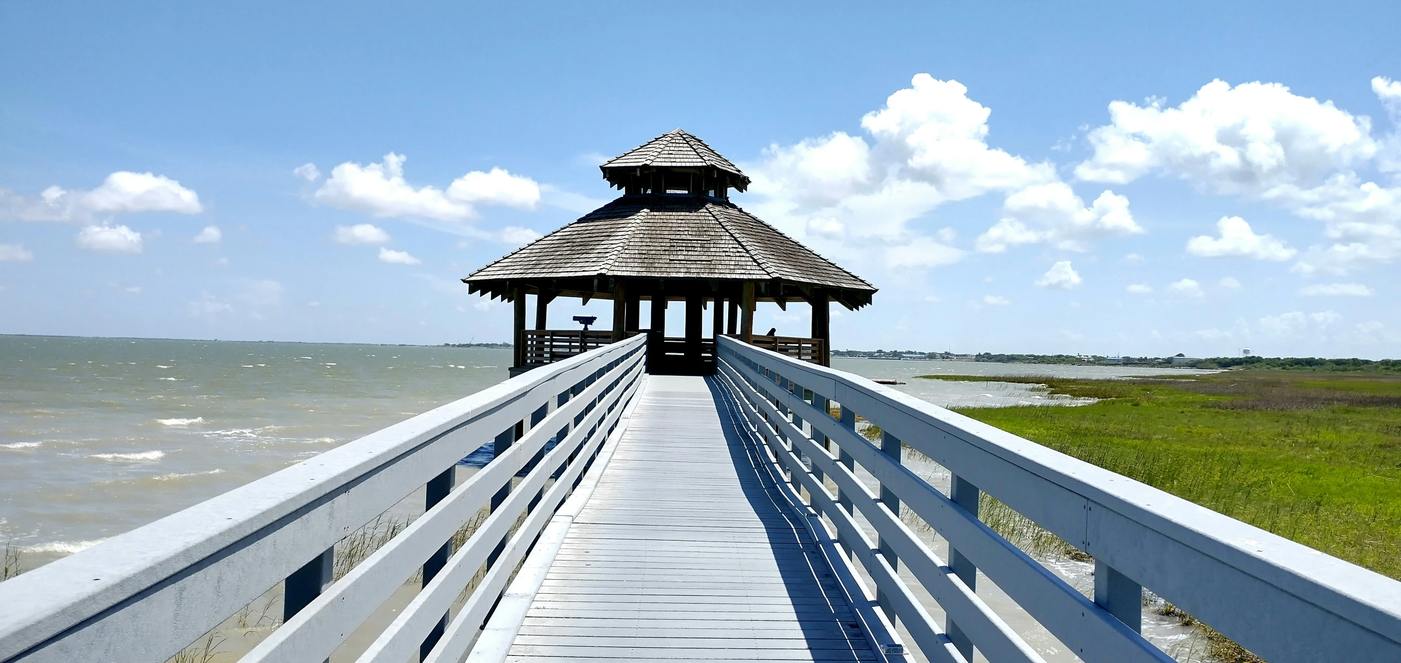 a long walkway to an overlook point at the ocean