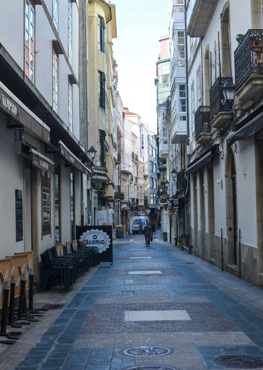 the woman is standing near a row of shops