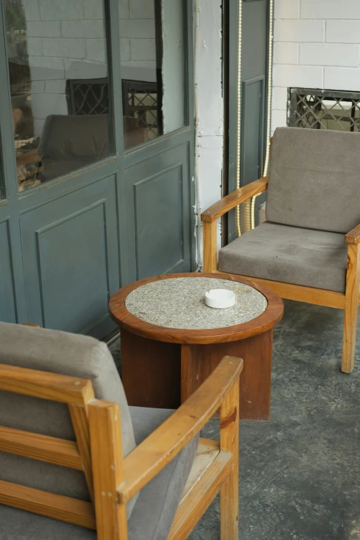 three chairs and one table sitting on the porch