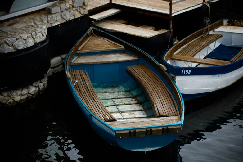 two rowboats tied to a pier side by side