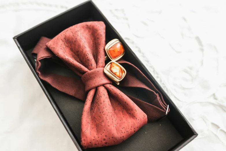 a box with a red bow and a pair of earrings in it
