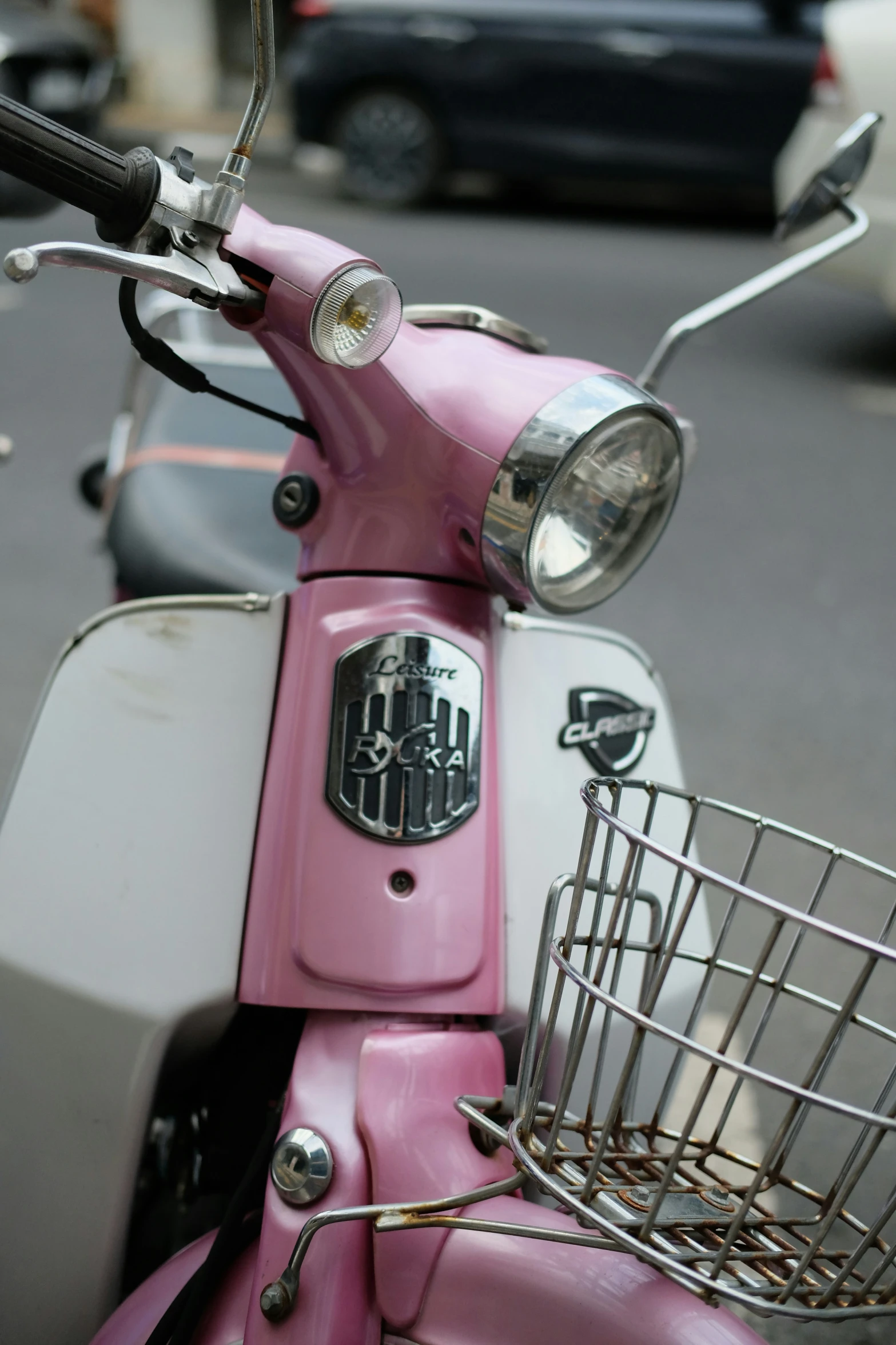 the motor scooter is pink, white and silver