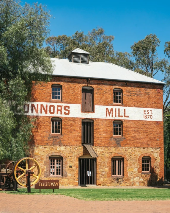 old brown brick building with sign for connors mill in front