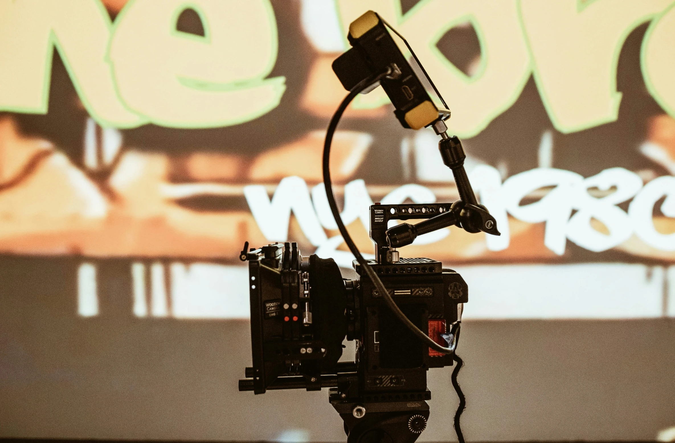 an industrial camera set up in front of a wall with a projector and movie equipment on it