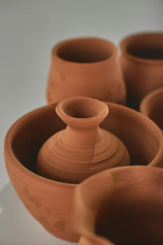 some clay vases sitting in an artistic manner