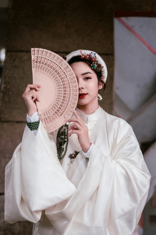 a woman with an elaborate chinese headpiece holding up a parasol