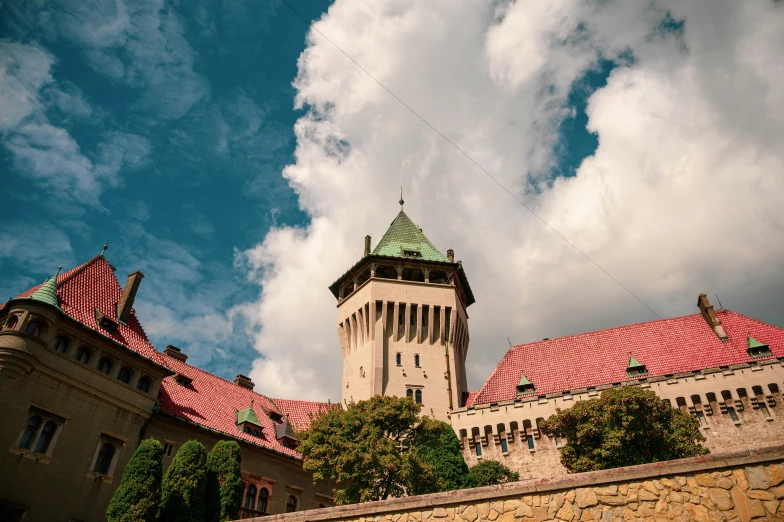 large old building with red tile roof and two towers