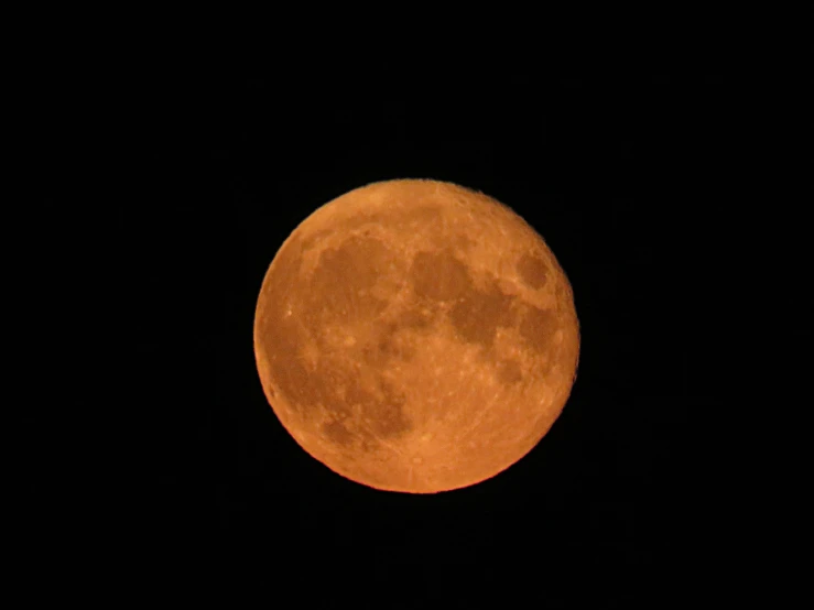 a full moon in the night sky taken from a distance