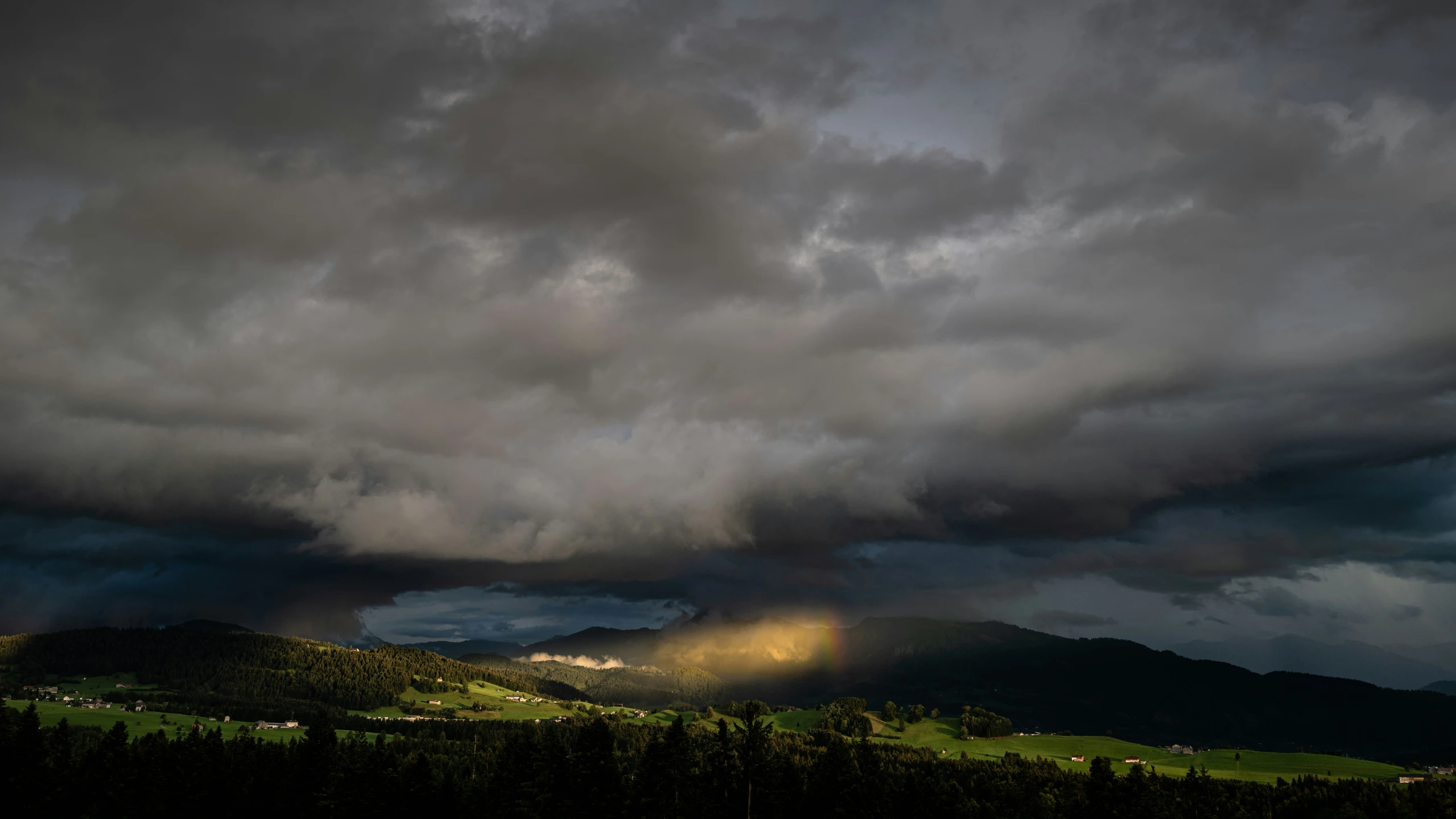 storm clouds hovers over the countryside at sunset