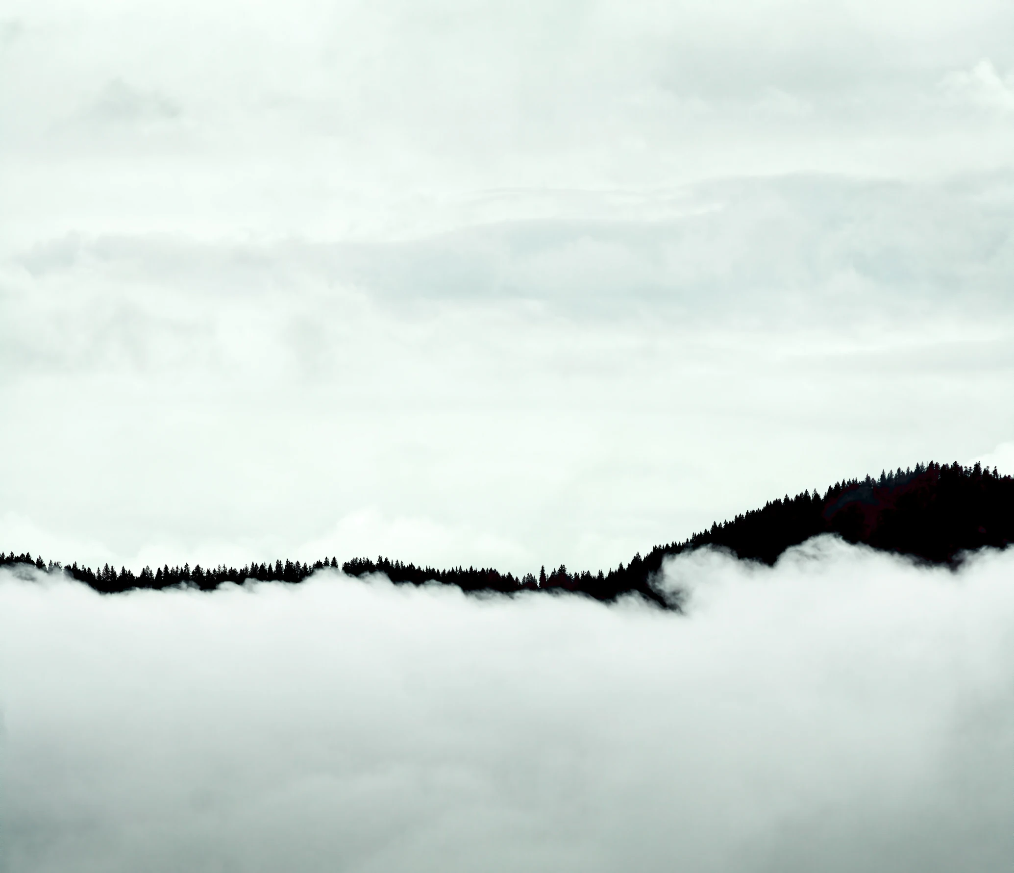 a mountain with thick clouds rolling over it