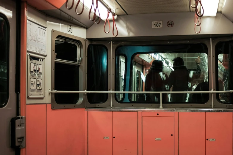 the inside of a train with people standing and sitting