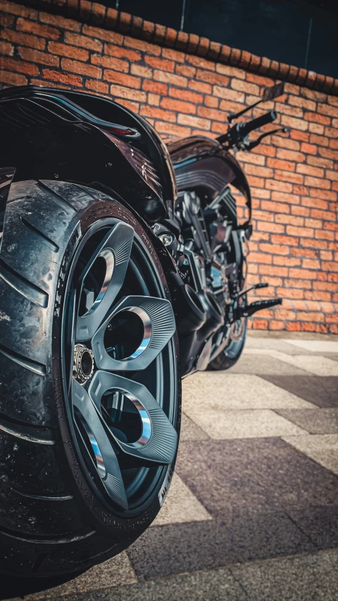 two black motorcycles parked next to a wall