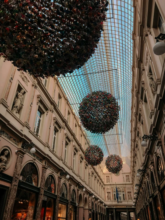 christmas decorations hanging from the ceiling inside a building