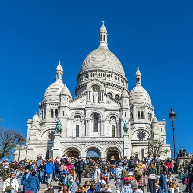 people sit in front of a very large building