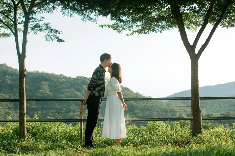 a man and woman standing next to each other on the grass