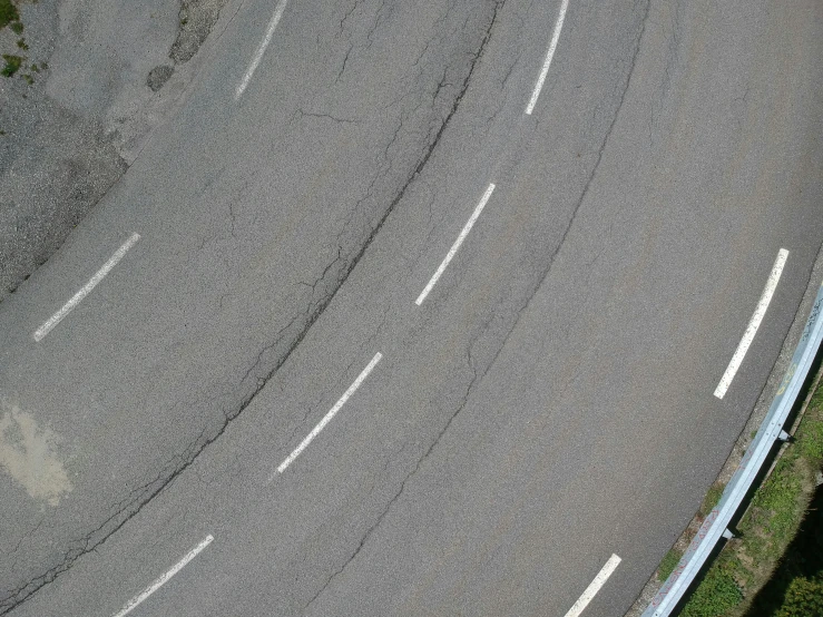 an aerial s of a two lane, straight - up curved road