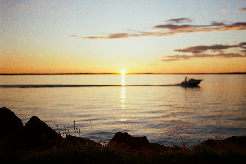 a boat is coming to shore near rocks and another boat