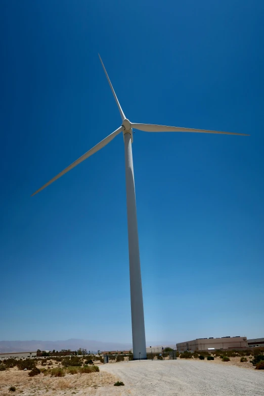 a wind turbine sitting on top of a sandy ground