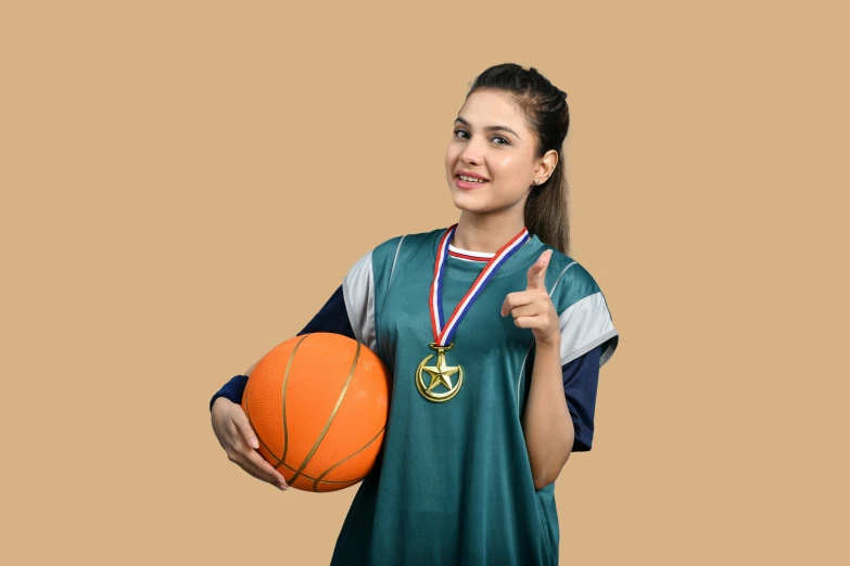 woman in green jersey holding a basketball with medal