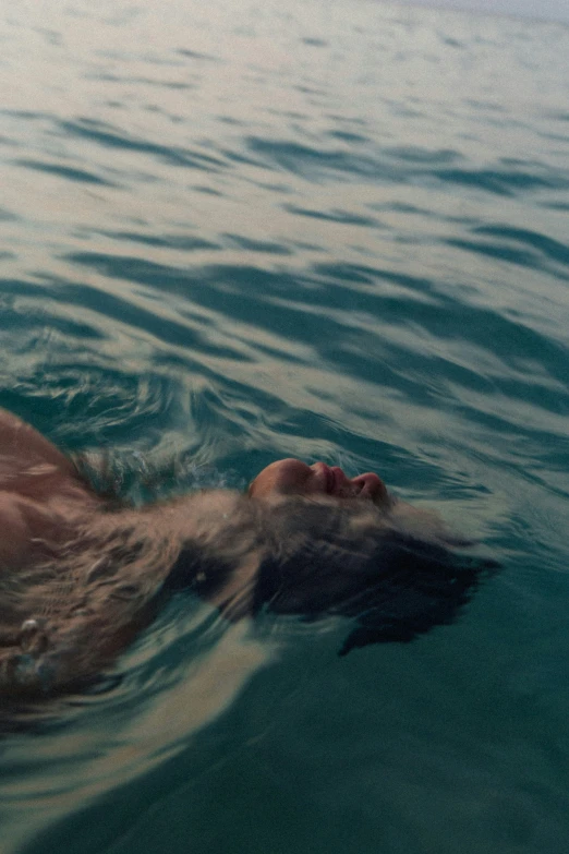 a man swimming in the ocean with a small frisbee