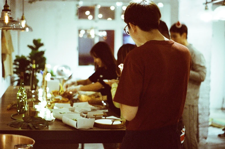 people standing and eating food at the table