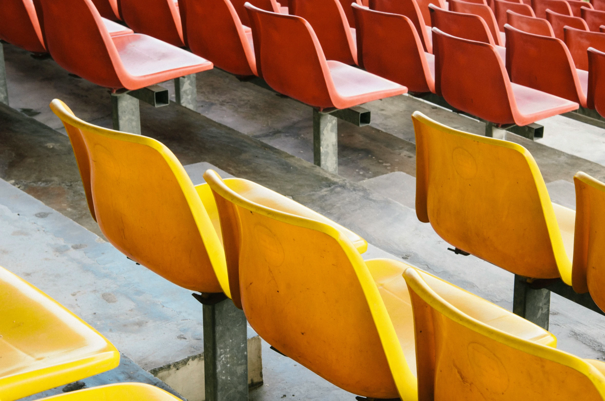 there are many yellow and red chairs in the stadium