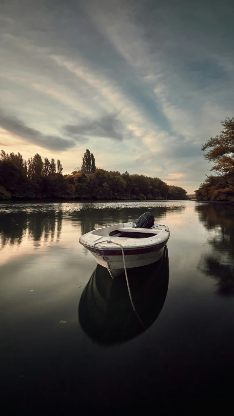 two boats floating on top of a lake near a forest