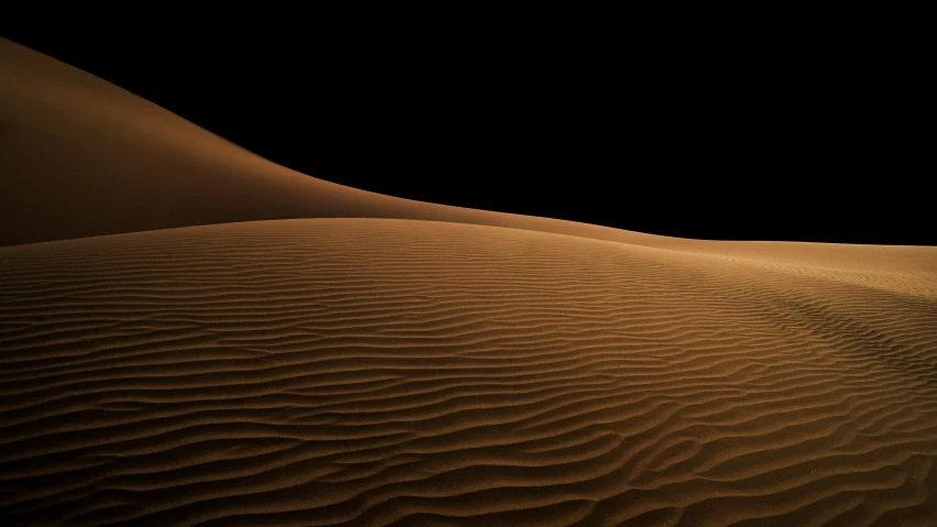 a lone man walking across the sand dunes