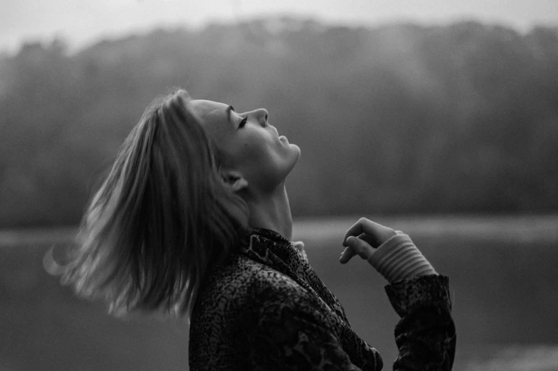 a woman looking up at the sky with a cigarette