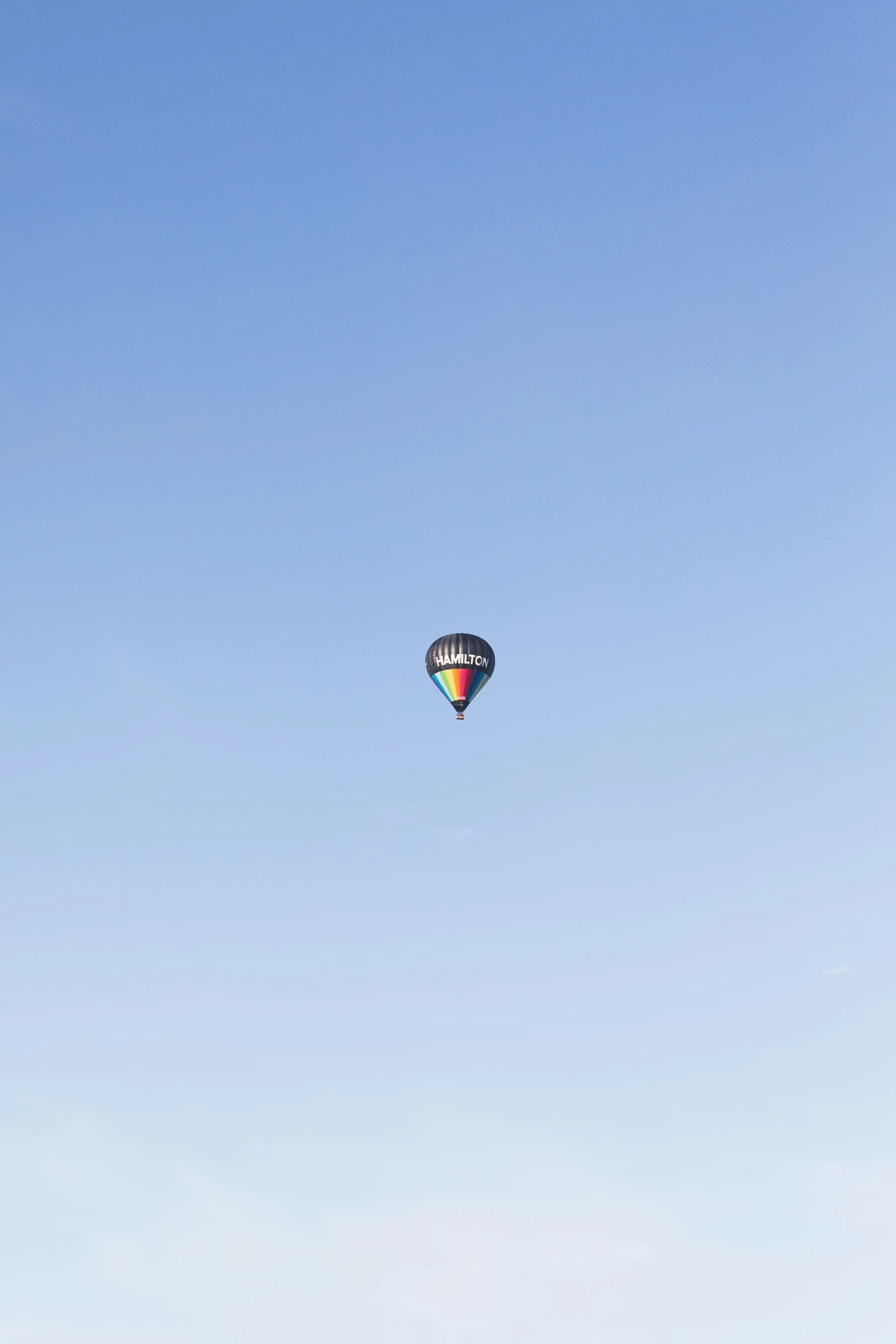 a large white balloon flies in the air over a field