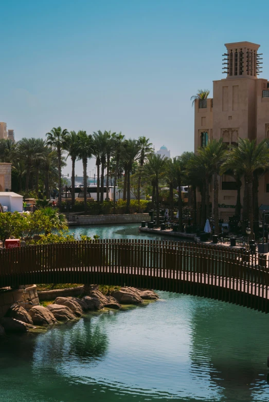 a small bridge is spanning a pool on a nice day